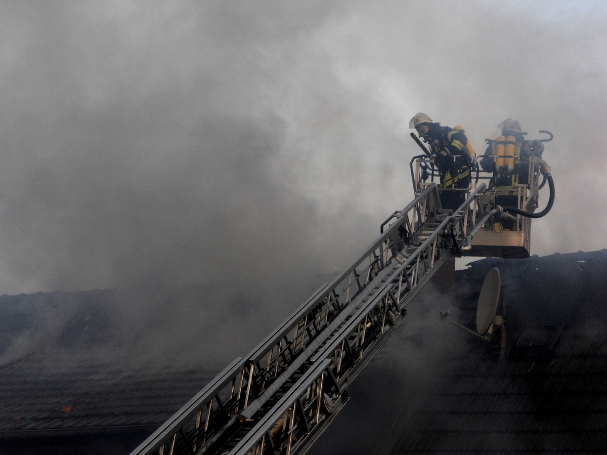 Fire brigade responding to a call at night with smoke in the background