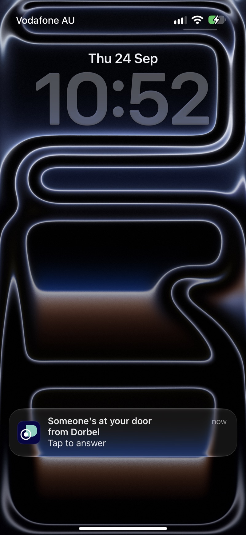 An iPhone lock screen showing a Dorbel notification reading: Someone's at your door, tap to answer